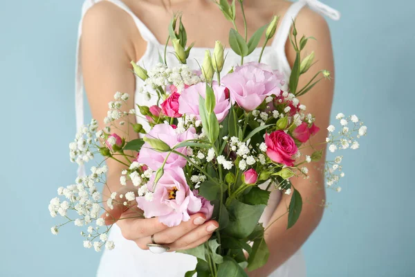 Žena s kyticí krásných květin na barevném pozadí, detailní záběr — Stock fotografie