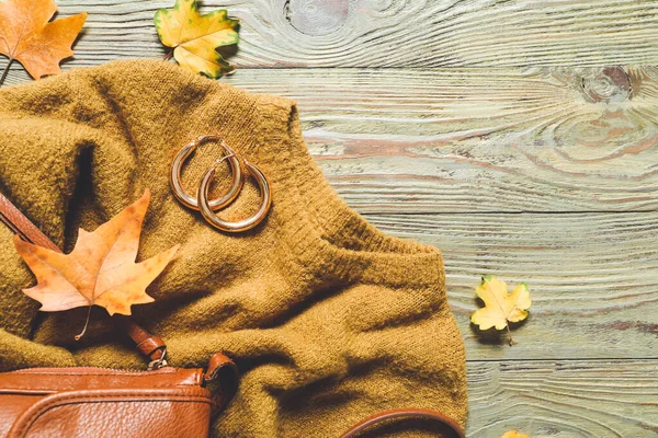 Beautiful autumn composition with clothes and leaves on wooden background — Stock Photo, Image