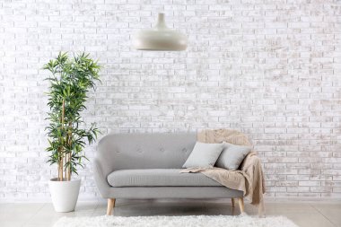 Kanepe ve tuğla duvarlı modern bir oda.