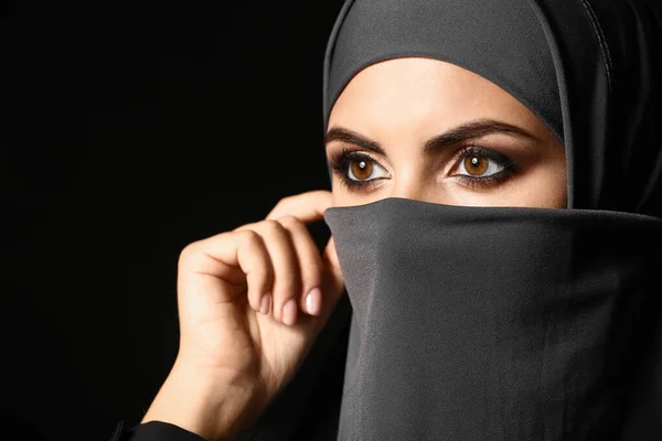 Schöne muslimische Frau auf dunklem Hintergrund — Stockfoto