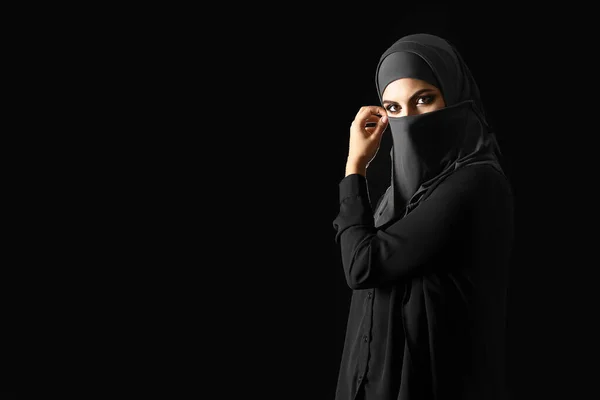 Schöne muslimische Frau auf dunklem Hintergrund — Stockfoto