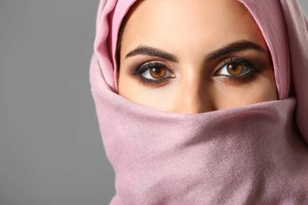 Portrait of beautiful Muslim woman on grey background, closeup — Stock Photo, Image