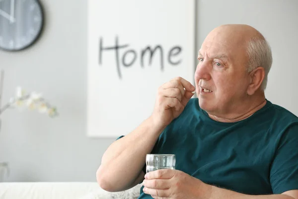 Anciano tomando medicamentos en casa —  Fotos de Stock