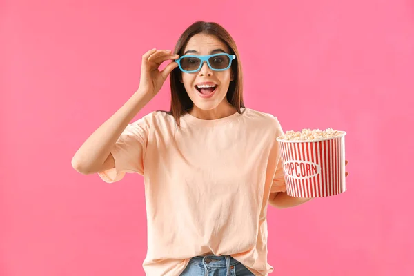 Surprised woman with popcorn on color background — Stock Photo, Image