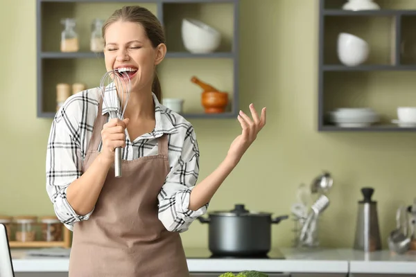 Mutfakta yemek yaparken güzel genç kadın şarkı — Stok fotoğraf