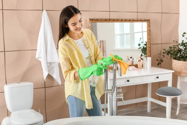 Wanita muda cantik membersihkan kamar mandi — Stok Foto
