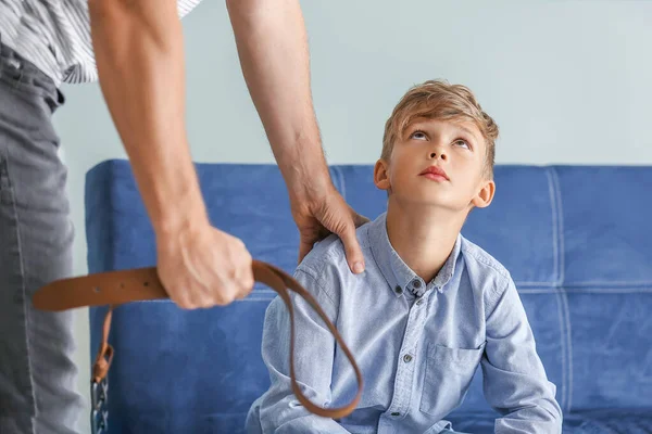 Un uomo che minaccia suo figlio a casa. Concetto di punizione fisica — Foto Stock