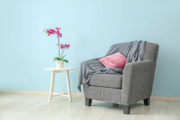 Comfortable armchair and table near color wall — Stock Photo, Image