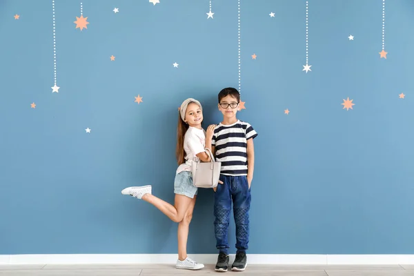 Leuke modieuze kinderen in de buurt van kleur muur — Stockfoto