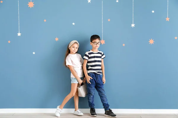 Leuke modieuze kinderen in de buurt van kleur muur — Stockfoto