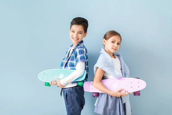 Bambini alla moda svegli con skateboard vicino alla parete a colori — Foto Stock