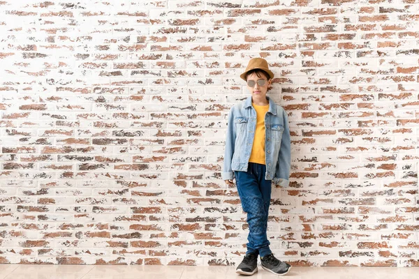 Cute fashionable boy against brick wall — Stock Photo, Image