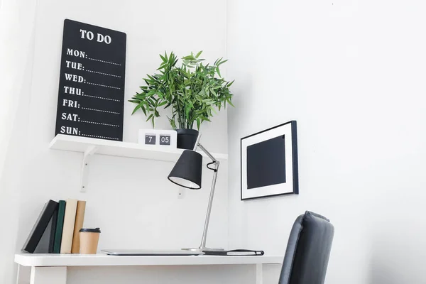 Moderno lugar de trabajo elegante con planta de interior cerca de la pared blanca — Foto de Stock