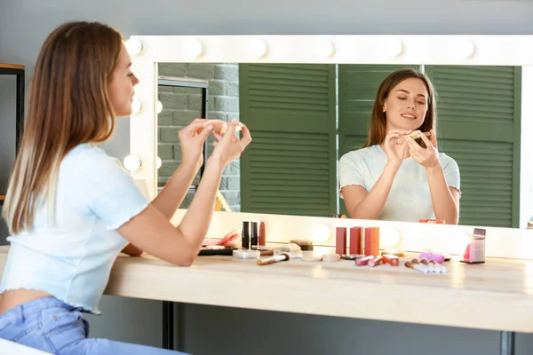 Hermosa joven aplicación de maquillaje delante del espejo — Foto de Stock