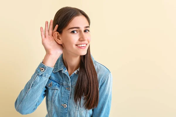 Ung kvinna med hörselskada på färgbakgrund — Stockfoto