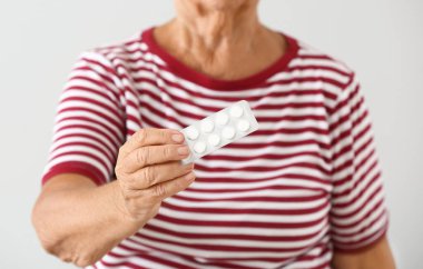 Yaşlı kadın açık renkli hapları ile