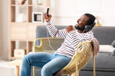 Yakışıklı Afrikalı-Amerikalı adam evde müzik dinliyor