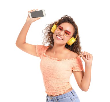 Güzel Afro-Amerikalı kadın beyaz arka planda müzik dinliyor.