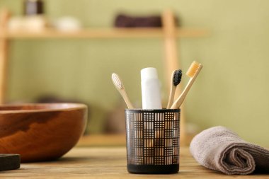 Diş fırçaları yapıştırıcı ve havluyla banyoda masanın üzerinde.