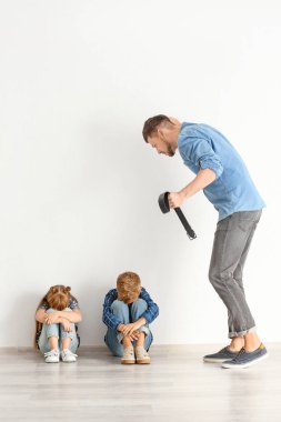 Küçük çocuklarını tehdit eden bir adam. Fiziksel ceza kavramı