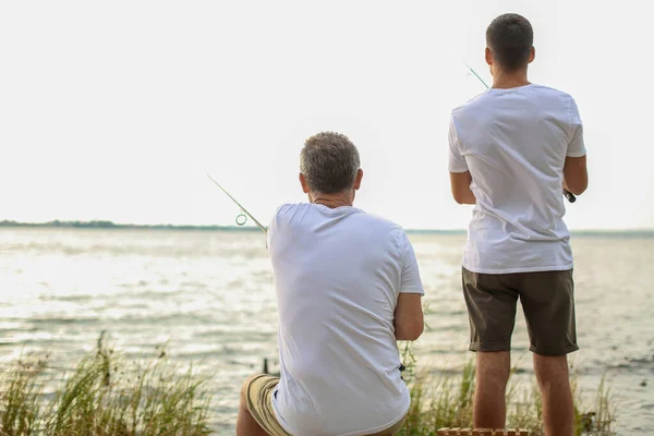 Joven y su padre pescando en el río — Foto de Stock