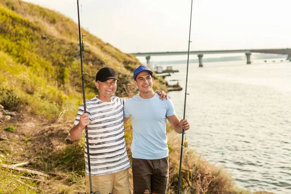 Joven y su padre pescando en el río — Foto de Stock