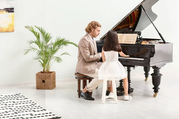피아노를 연주하는 어린 소녀를 가르치는 남자 — 스톡 사진