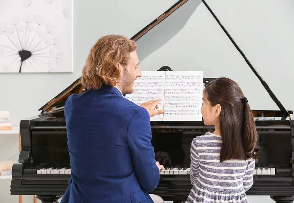 Ο άνθρωπος διδάσκει μικρό κορίτσι για να παίξει πιάνο — Φωτογραφία Αρχείου