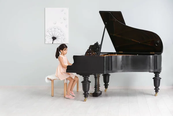 Menina tocando piano de cauda dentro de casa — Fotografia de Stock