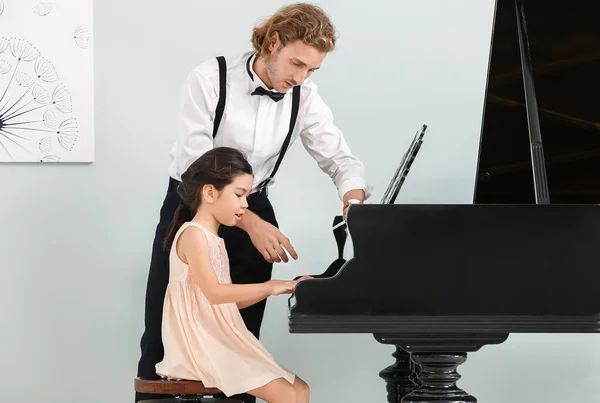 Homem ensinando menina para tocar piano — Fotografia de Stock