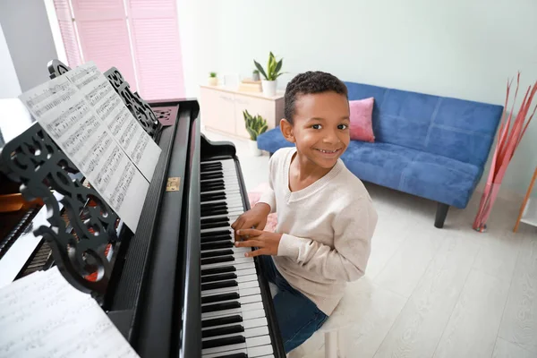 Pequeño chico afroamericano tocando el piano de cola en casa — Foto de Stock