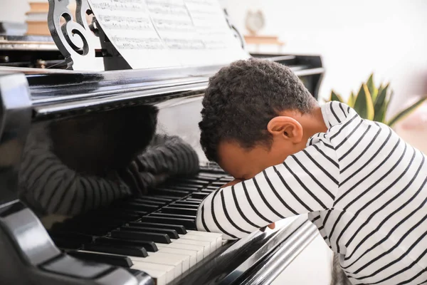 Tired African-American boy sleeping at grand piano — Stock Photo, Image