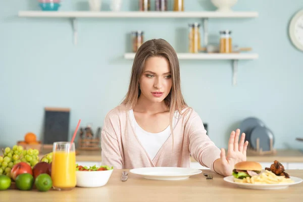 Frau weigert sich, ungesundes Essen in der Küche zu essen. Ernährungskonzept — Stockfoto