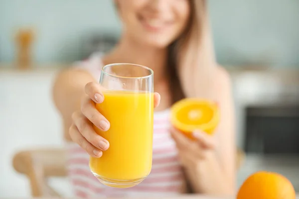 Jovem com suco de laranja saudável na cozinha, close-up. Conceito de dieta — Fotografia de Stock