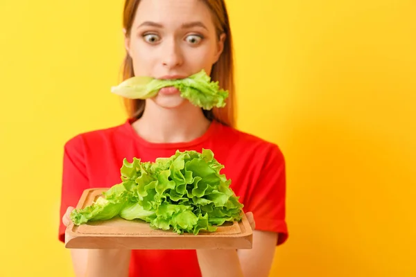Наголошена жінка їсть здоровий салат на кольоровому фоні. Концепція дієти — стокове фото
