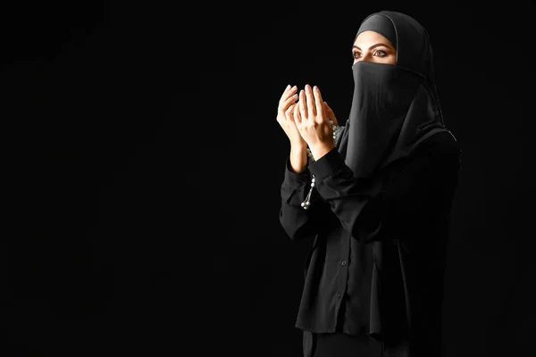 Schöne muslimische Frau, die vor dunklem Hintergrund betet — Stockfoto