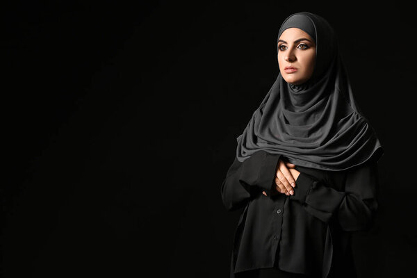 Beautiful Muslim woman on dark background