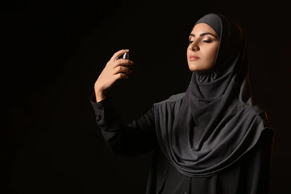Gyönyörű muszlim nő parfümmel sötét háttér — Stock Fotó