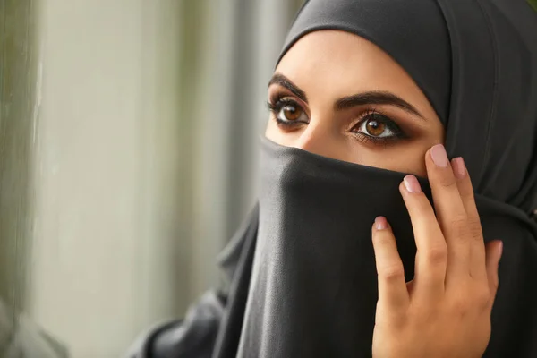 Portrait of beautiful Muslim woman near window — Stock Photo, Image