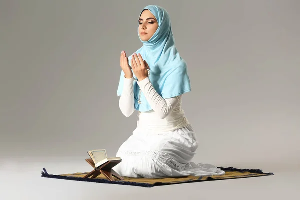 Imádkozó muszlim nő szürke háttér — Stock Fotó