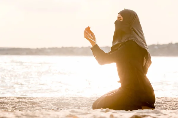 Beautiful Muslim woman praying near river — Stock Photo, Image