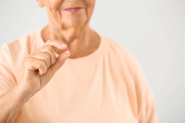 Yaşlı kadın açık renkli, closeup doğum kontrol hapı ile — Stok fotoğraf