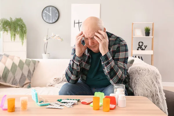 Elderly man with pills at home — Stock Photo, Image