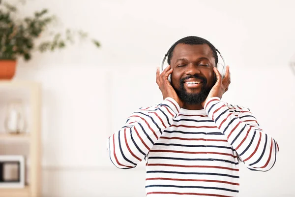 Hombre afroamericano guapo escuchando música en casa — Foto de Stock