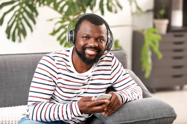 Hombre afroamericano guapo escuchando música en casa — Foto de Stock