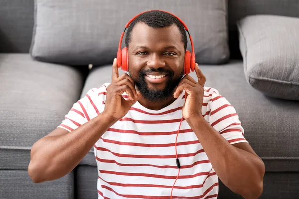 Handsome African-American man listening to music at home — Stock Photo, Image