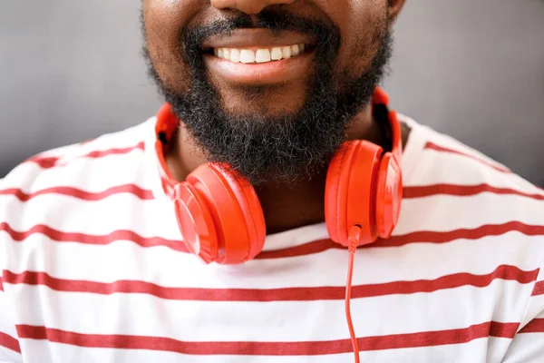 Jóképű afro-amerikai férfi fülhallgatóval otthon, közelkép — Stock Fotó
