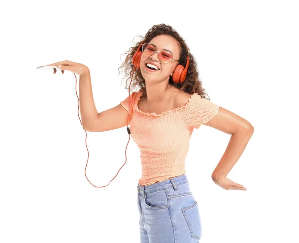 Beautiful African-American woman dancing and listening to music on white background — Stock Photo, Image