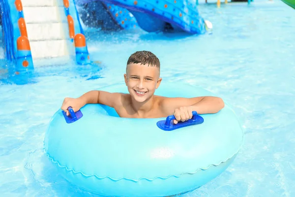 Rapaz bonito em anel de natação no parque aquático — Fotografia de Stock