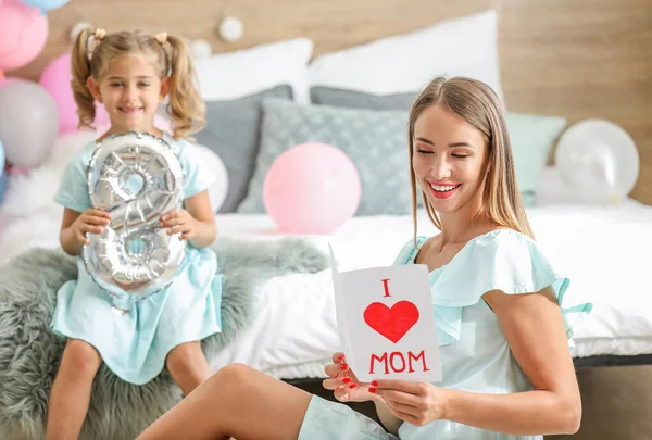 Little girl congratulating her mother on International Women's Day at home — Stock Photo, Image